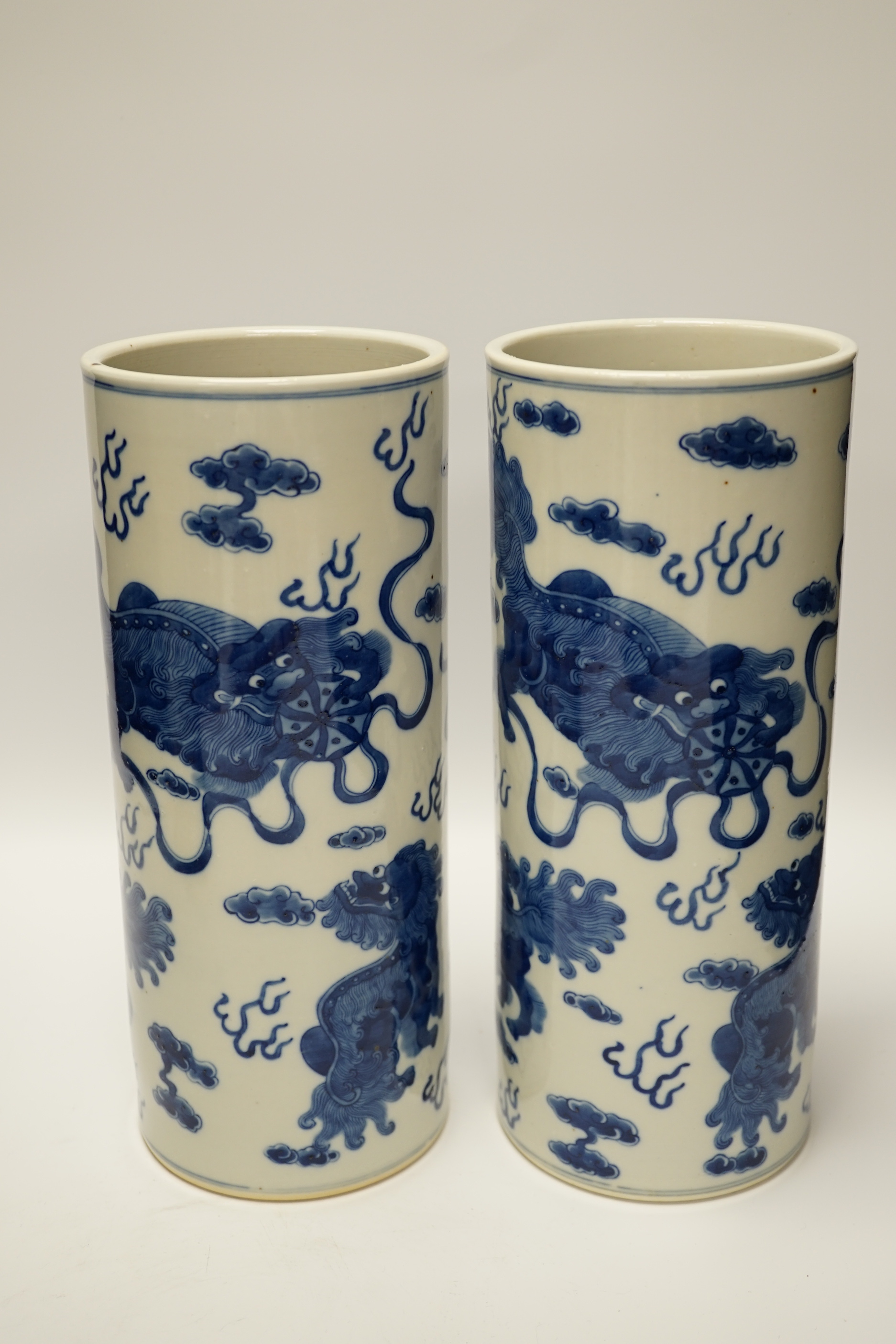 A pair of Chinese blue and white cylindrical hat stands, 29cm high and a Japanese porcelain vase modelled as bamboo